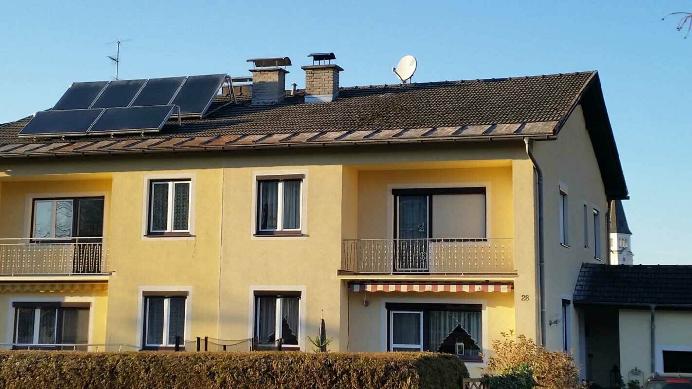 Hus med flera partier innan takrenovering med PREFA-takplattor i Österrike
