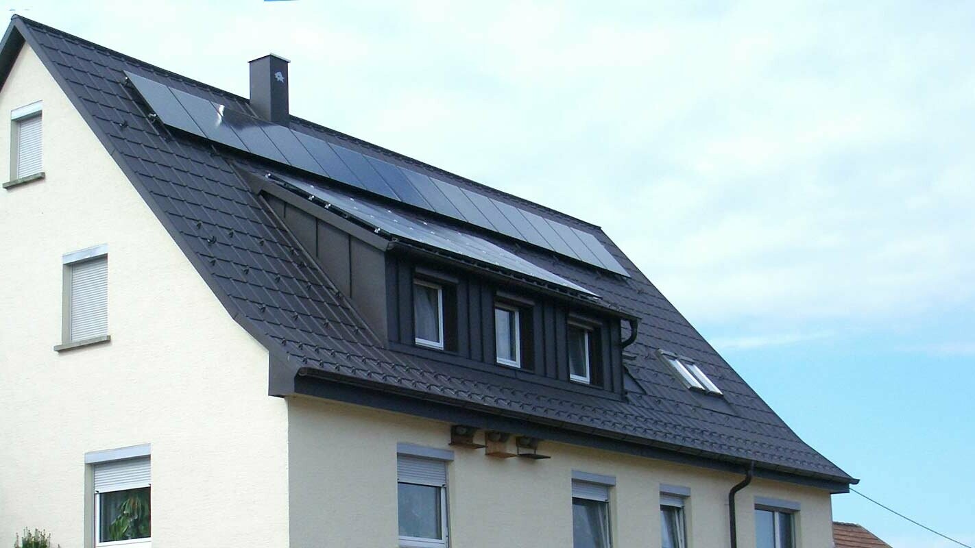nyrenoverat tak med PREFA takpanel i antracit, med takkupan beklädd med Prefalz; På taket finns ett solcellssystem.