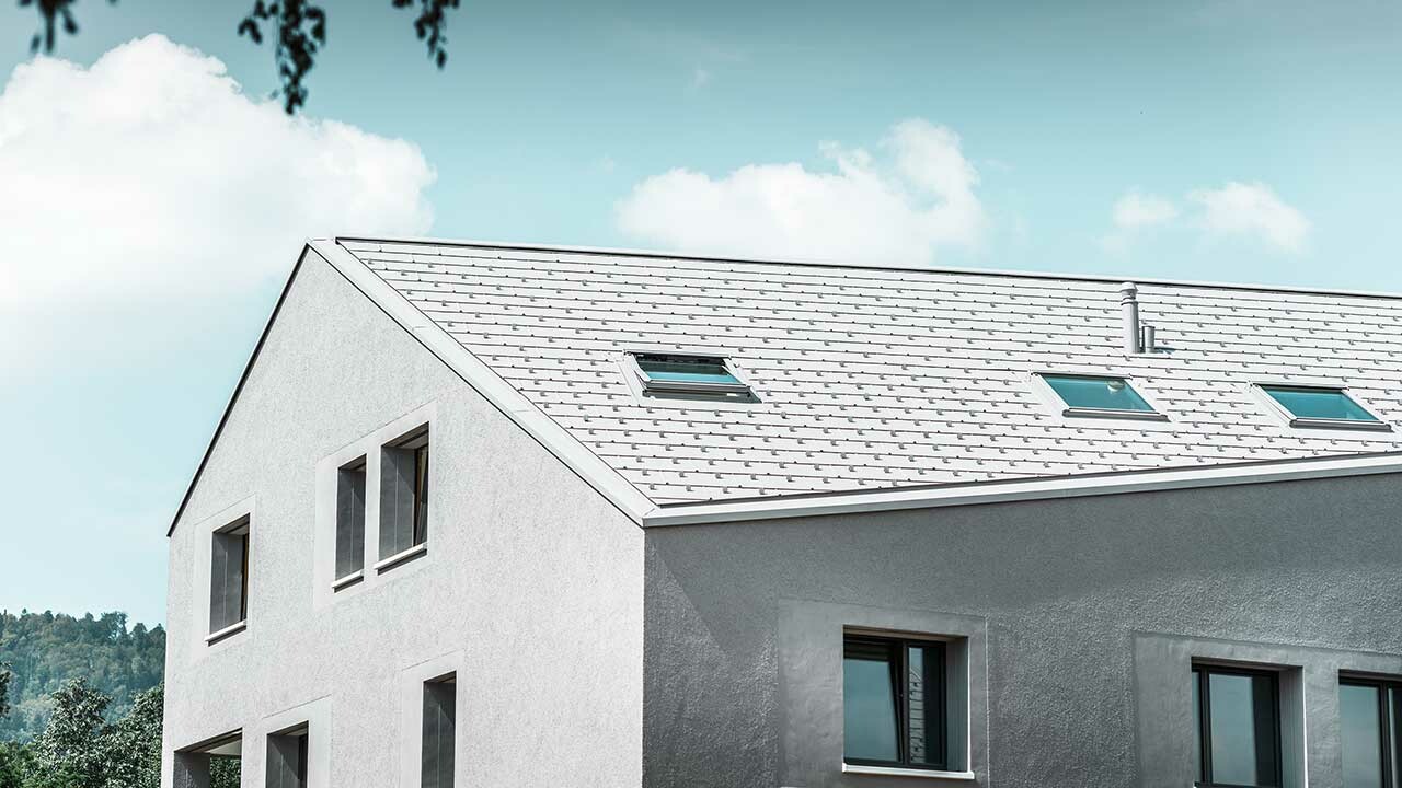 Flerfamiljshus med sluttande takfot och vit takpanel FX.12.