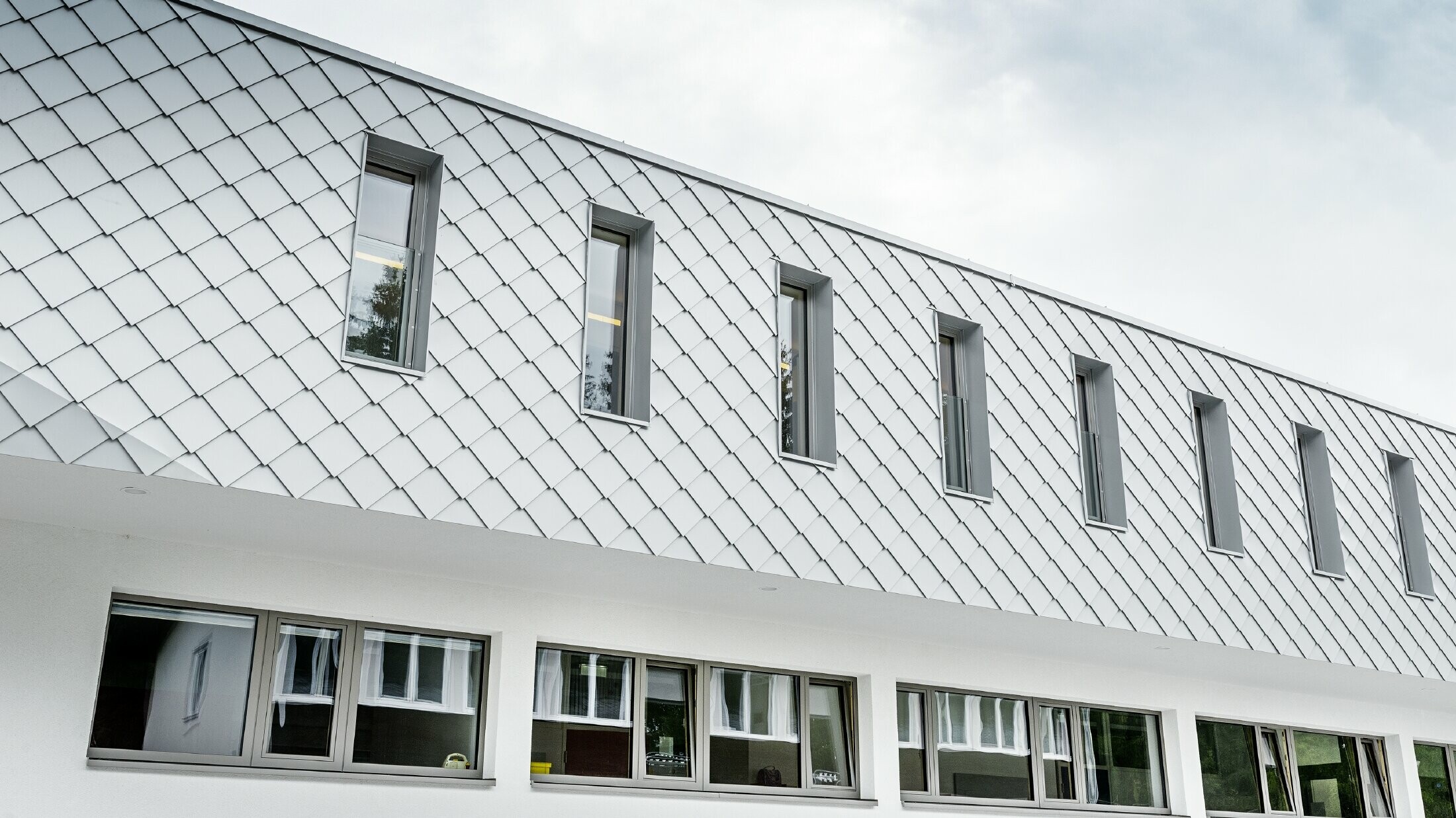 Nybyggd förskola i Kaprun med en modern aluminiumfasad med PREFA väggromb i prefavit