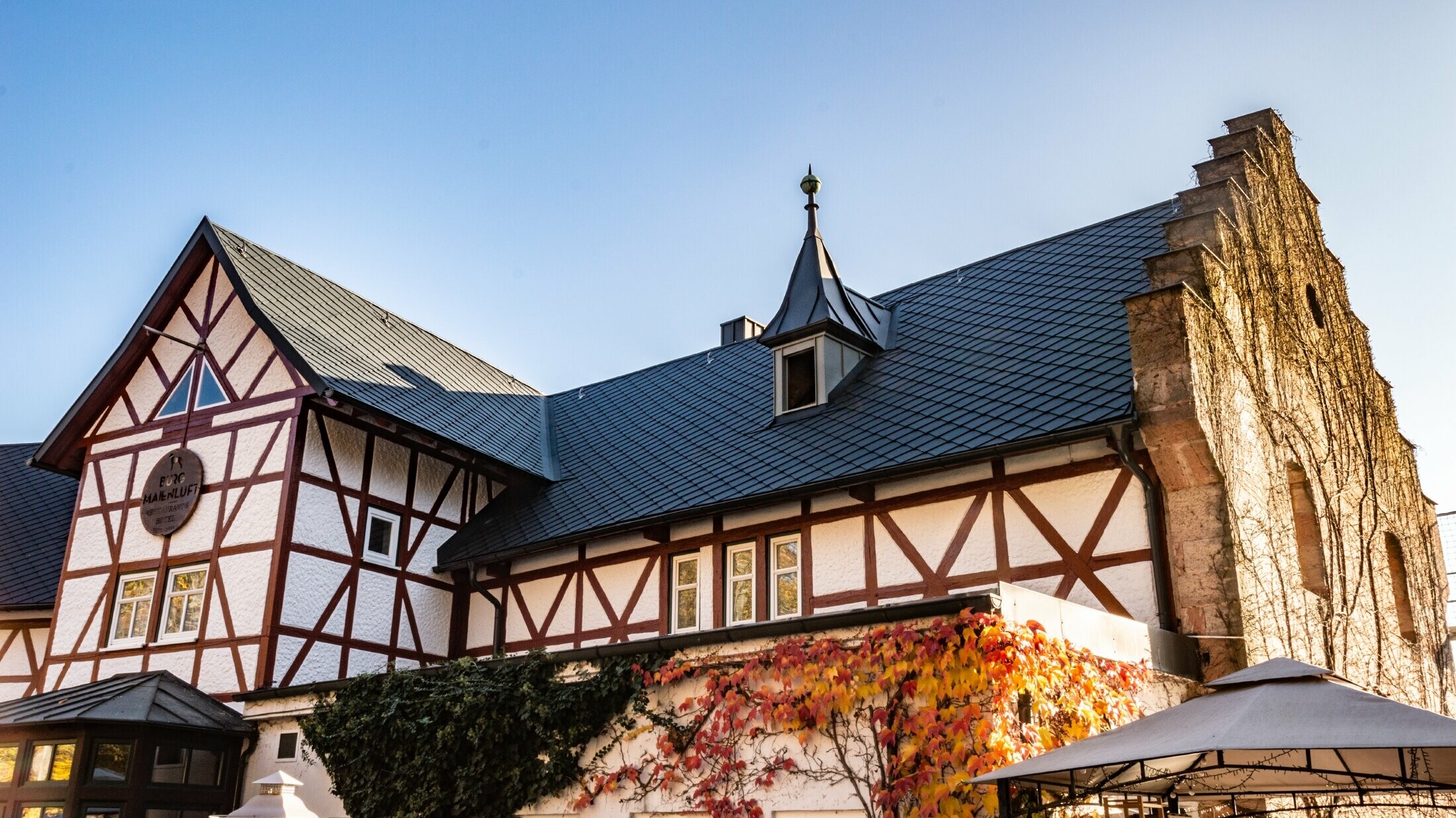 Hotel Burg Maienluft renoverades med PREFA väggromber 29 × 29 i antracitgrått, fasaden är en korsvirkesfasad.