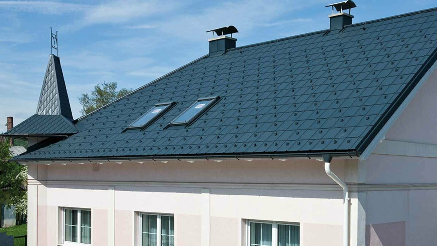 Hus efter takrenovering med PREFA takplattor i Österrike - tidigare Eternit fibercement med litet torn och rosa fasad