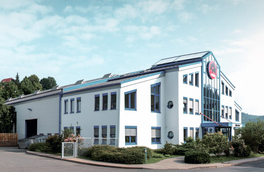 PREFA-företagsbyggnad med blå fönster och vit fasad i Wasungen, Tyskland.