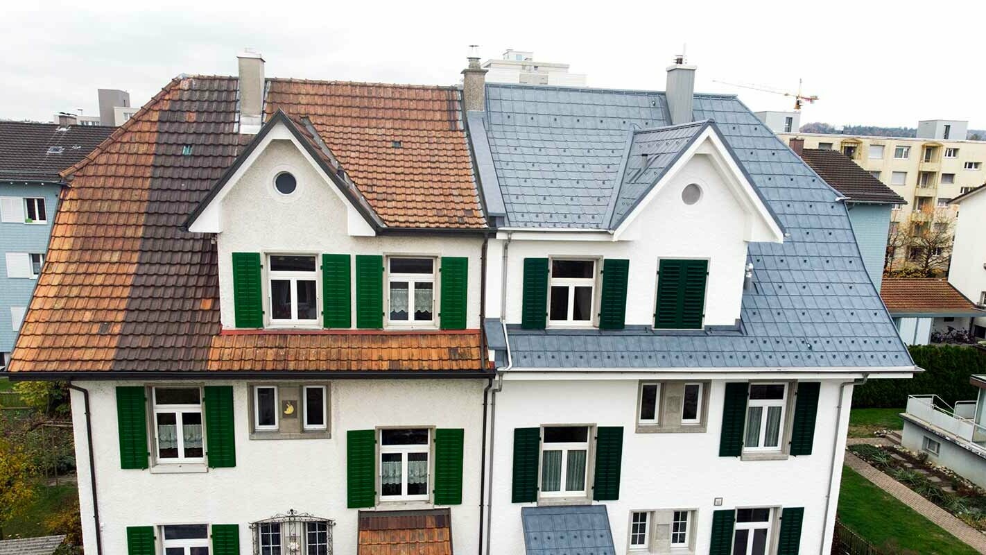 Radhus i Schweiz; Den vänstra delen av byggnaden har ännu inte renoverats och är fortfarande täckt med färgade takplattor. Den högra delen av byggnaden var täckt med PREFAs takplattor i stengrått.