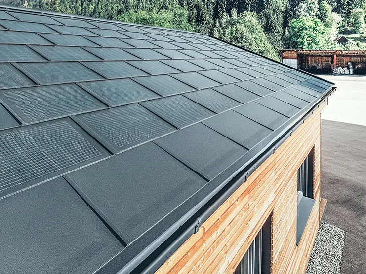 PREFA solpanel i stort utförande i kombination med takplatta R.16 i svart, rektangulär ränna och lärkträfasad