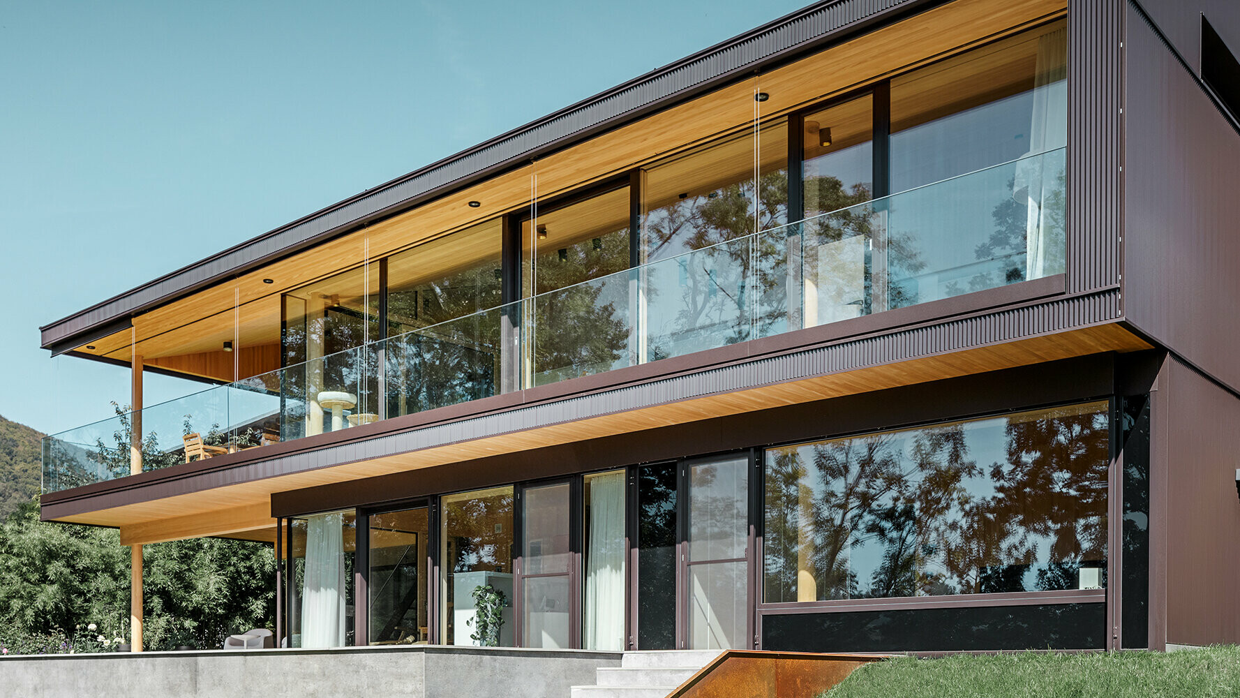 Nytt enfamiljshus med stora glasytor och brun aluminiumfasad