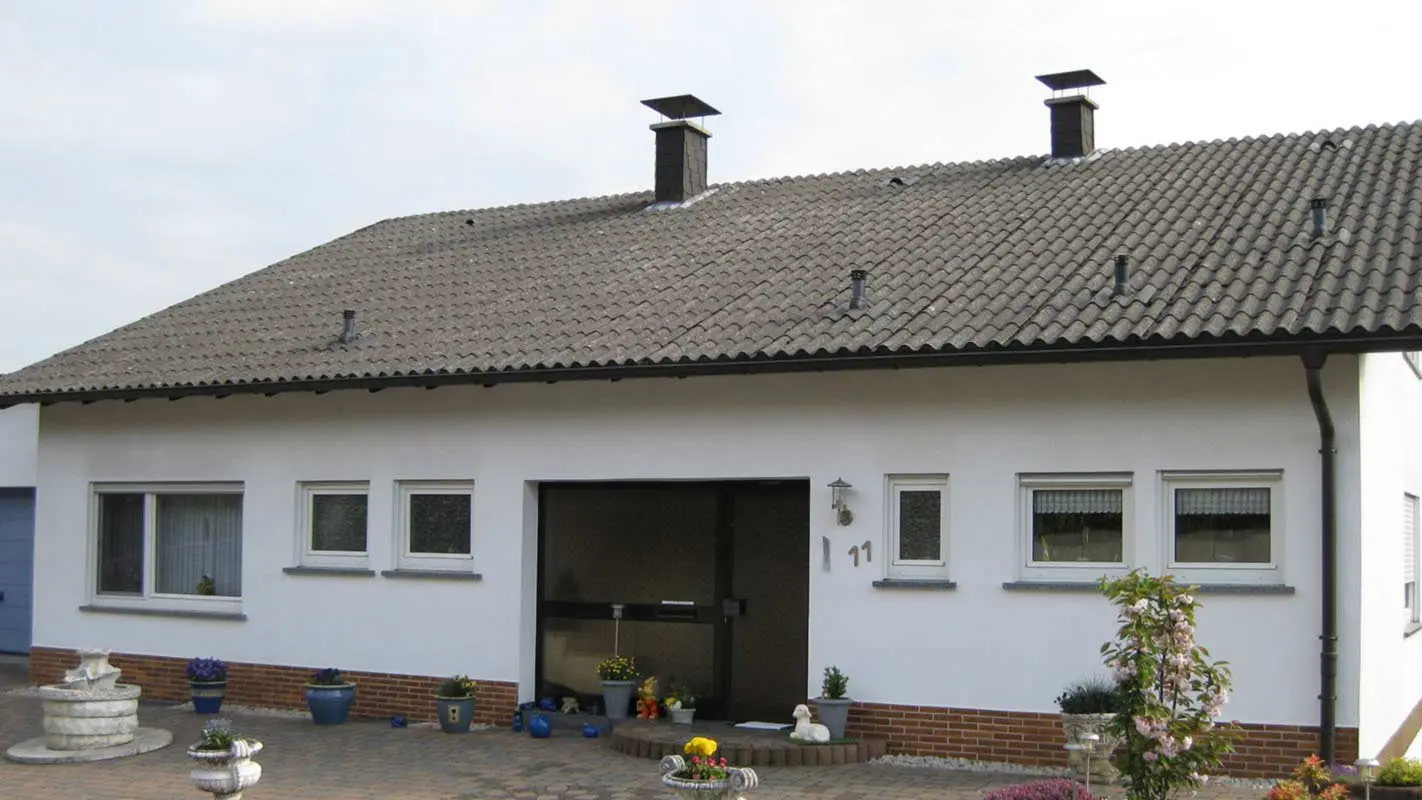 Bostadshus med veckad fibercement innan takrenovering med PREFA takplattor