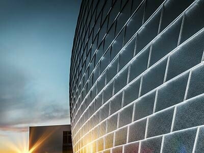 Sonnenspiegelung an den naturblanken Wandschindeln der Sporthalle in Tschechien