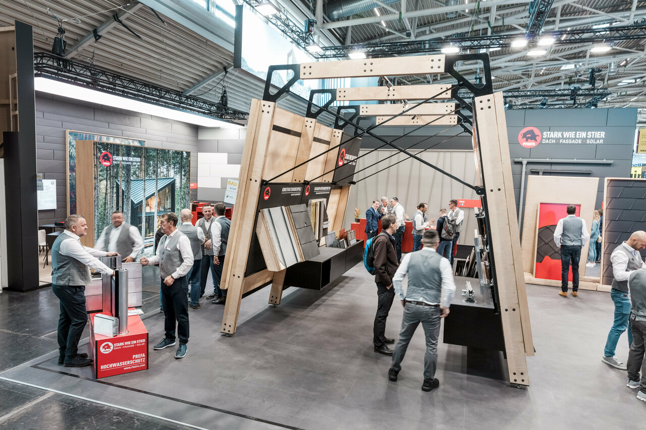 PREFAs livliga mässmonter med mässväggar som visar PREFAs tak- och fasadprodukter i aluminium.
