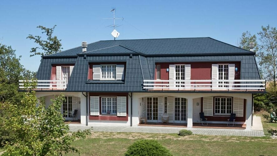 Antracitfärgade takplattor i aluminium från PREFA pryder taket på den här italienska villan
