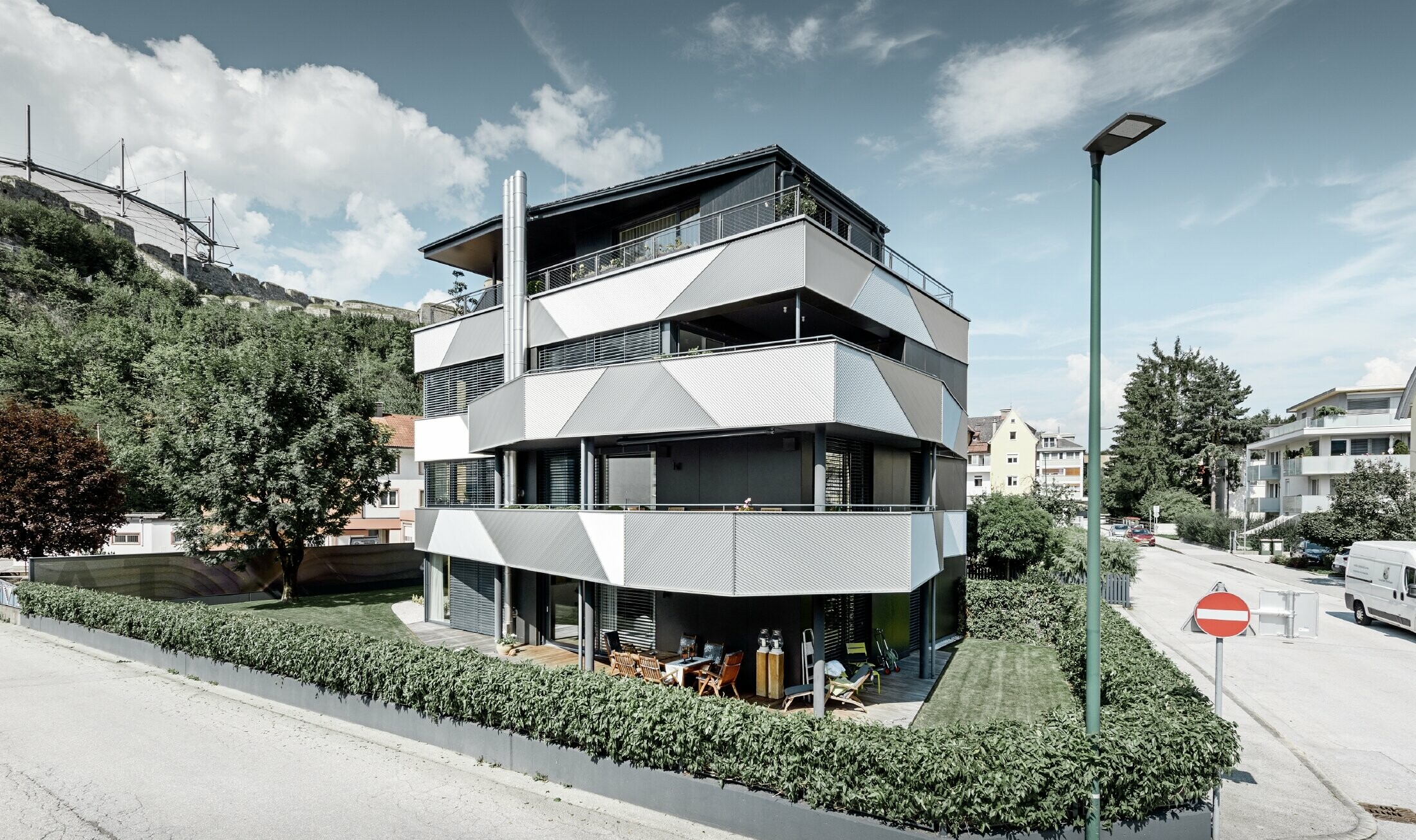 Fasaddesign med diagonalt monterade sicksackprofiler från PREFA på ett flerfamiljshus i Kufstein.