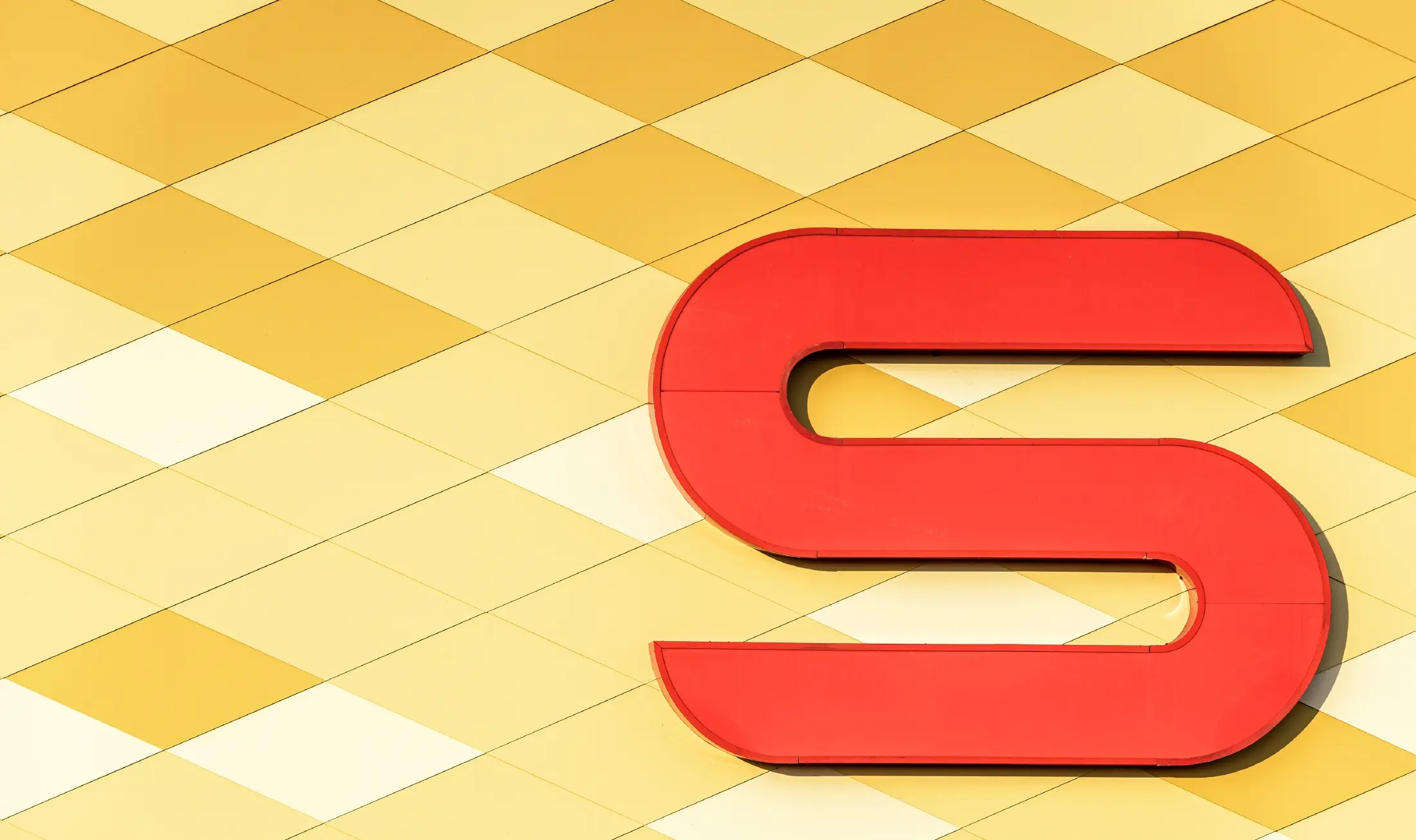 Spar-filial med en rutmönstrad aluminiumfasad i gulorange och Spar-logo