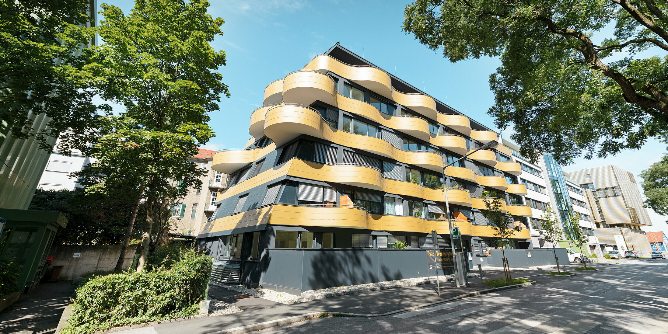 Bostadshuset "Goldene Welle" i Graz, Österrike med aluminiumkompositskiva i guld och rundade, vågiga balkonger 