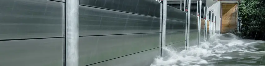 Närbild av översvämningsskyddet PREFA av aluminium, som alltid står emot översvämningskatastrofer och skyddar villan i bakgrunden.