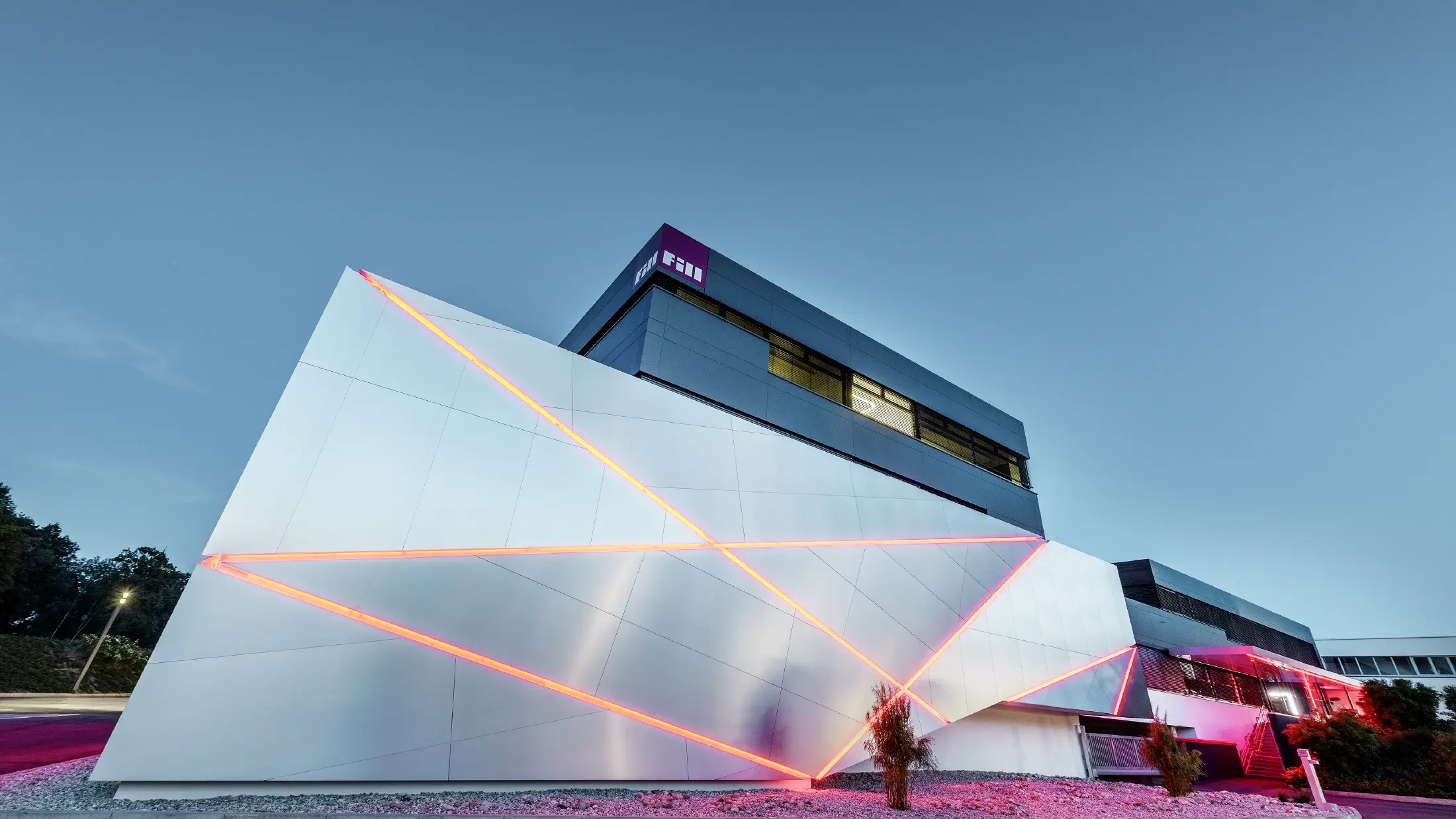 Fill företagsbyggnad med en futuristisk fasad av samverkansplattor i borstad aluminium och bakgrundsbelysta fogar