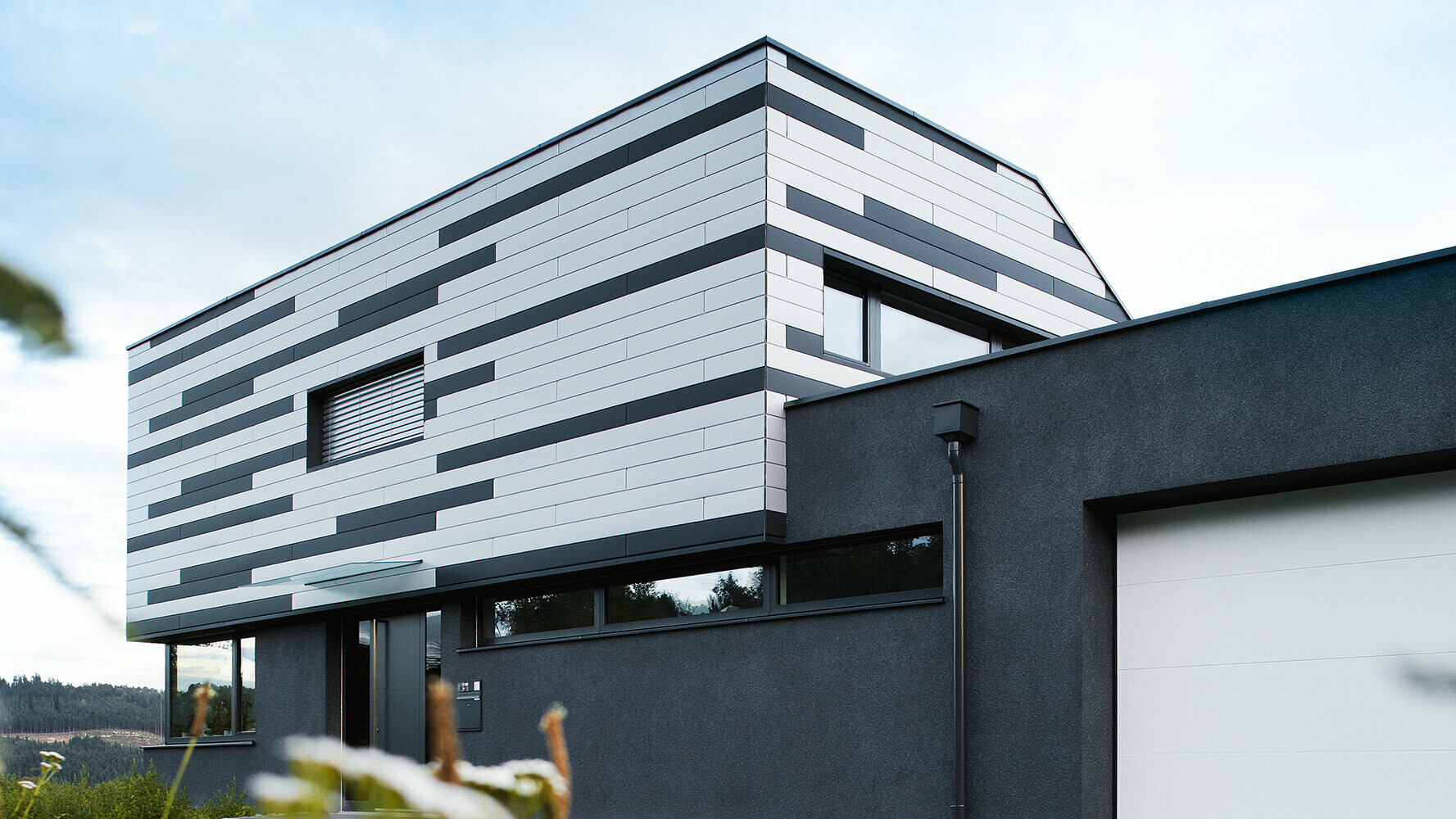 Modernt enfamiljshus med kreativt designad fasad. PREFA Sidings i silver (specialfärg) och antracit med matt yta monterades om vartannat.
