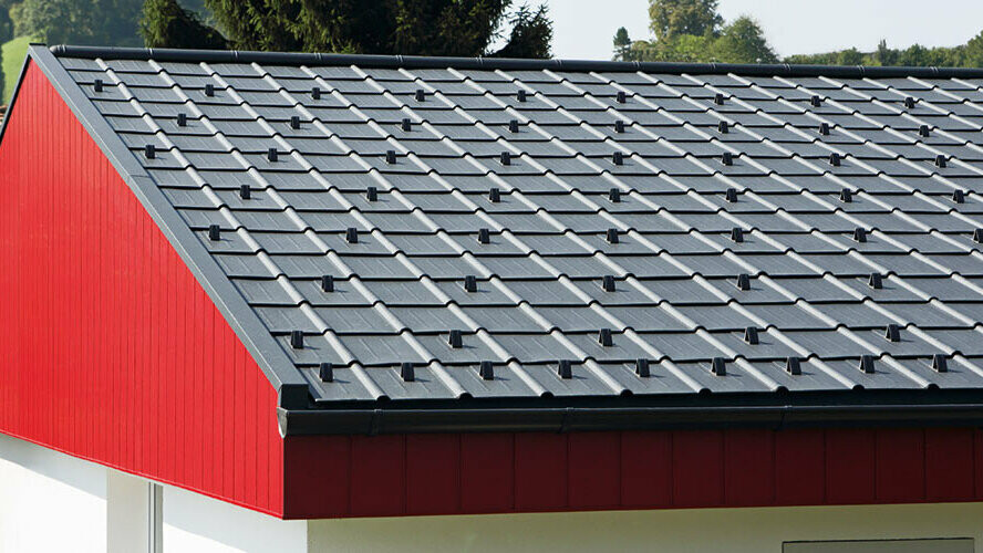 Gavelbeklädnad i rött med PREFA takpanel i aluminium som lagts vertikalt. På taket lades PREFA takplatta i P.10 antracitgrå.