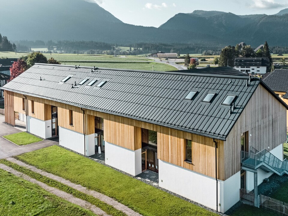Uteförskola i Bad Mitterndorf med stort PREFALZ-tak i P.10 antracit och träfasad