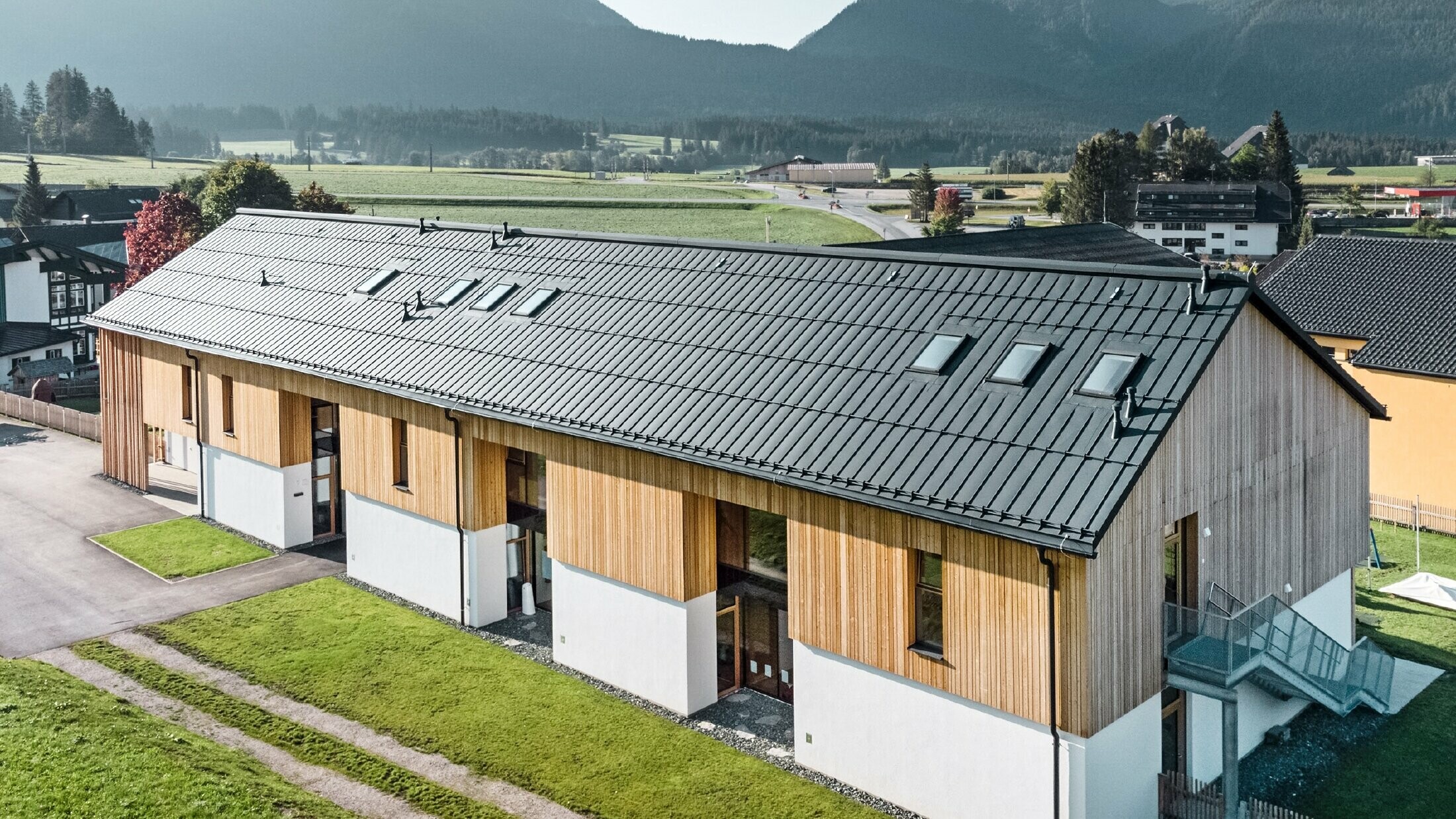 Uteförskola i Bad Mitterndorf med stort PREFALZ-tak i P.10 antracit och träfasad