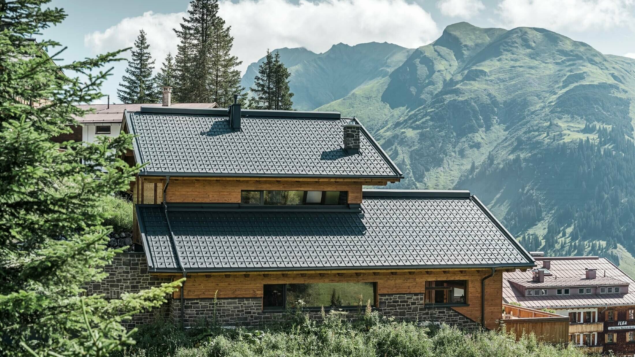 Hus i alpint läge med antracitfärgade PREFA-takplattor som taktäckning