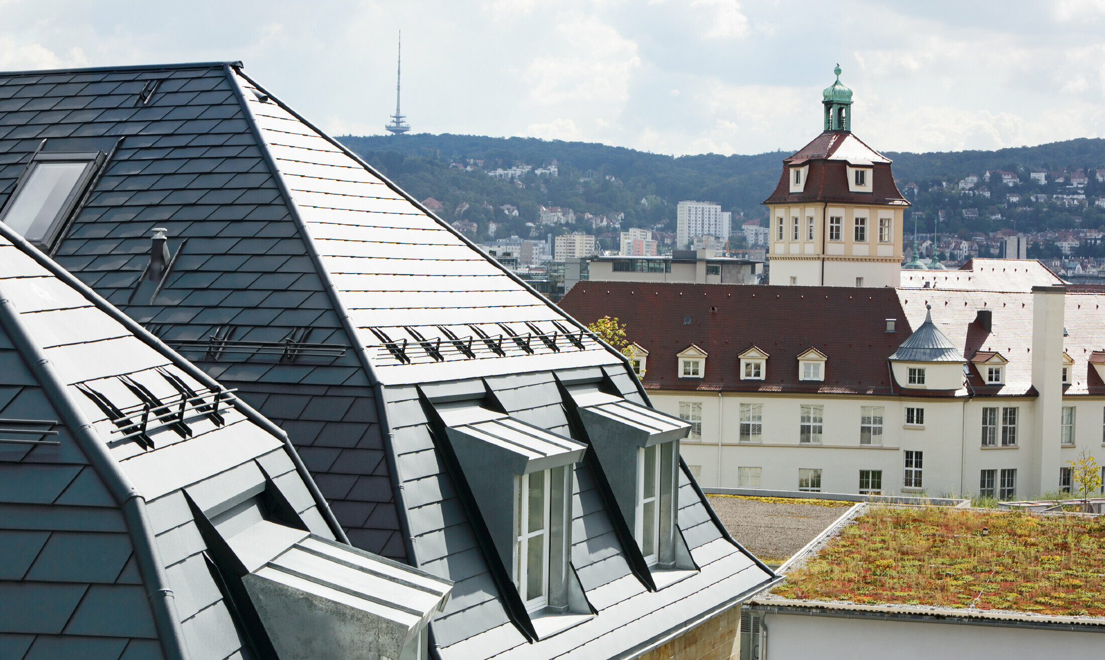 Gammalt rådhus i Stuttgart med brutet tak och många takkupor med fönster, beklätt med aluminumshingel från PREFA i P.10 antracit