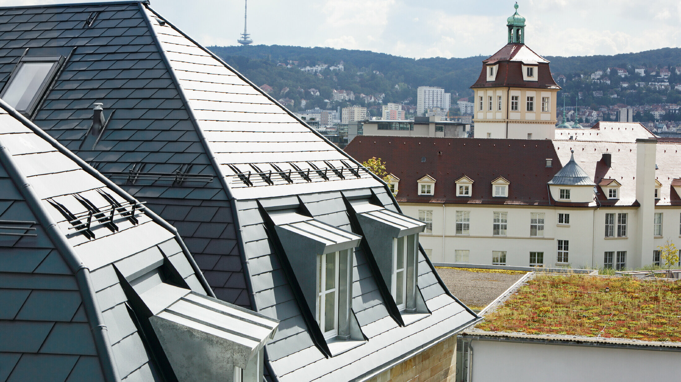 Gammalt rådhus i Stuttgart med brutet tak och många takkupor med fönster, beklätt med aluminumshingel från PREFA i P.10 antracit