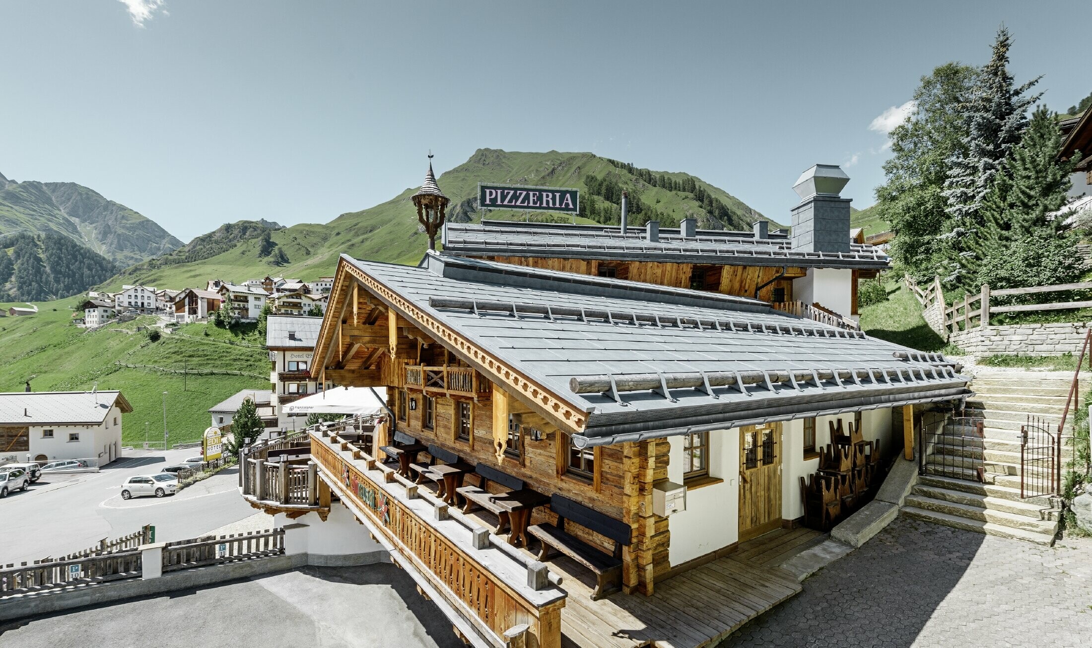 Restaurang Almrausch med utsikt över bergen och ett PREFA-tak med takpanelen FX.12 i stengrått och snörasskydd
