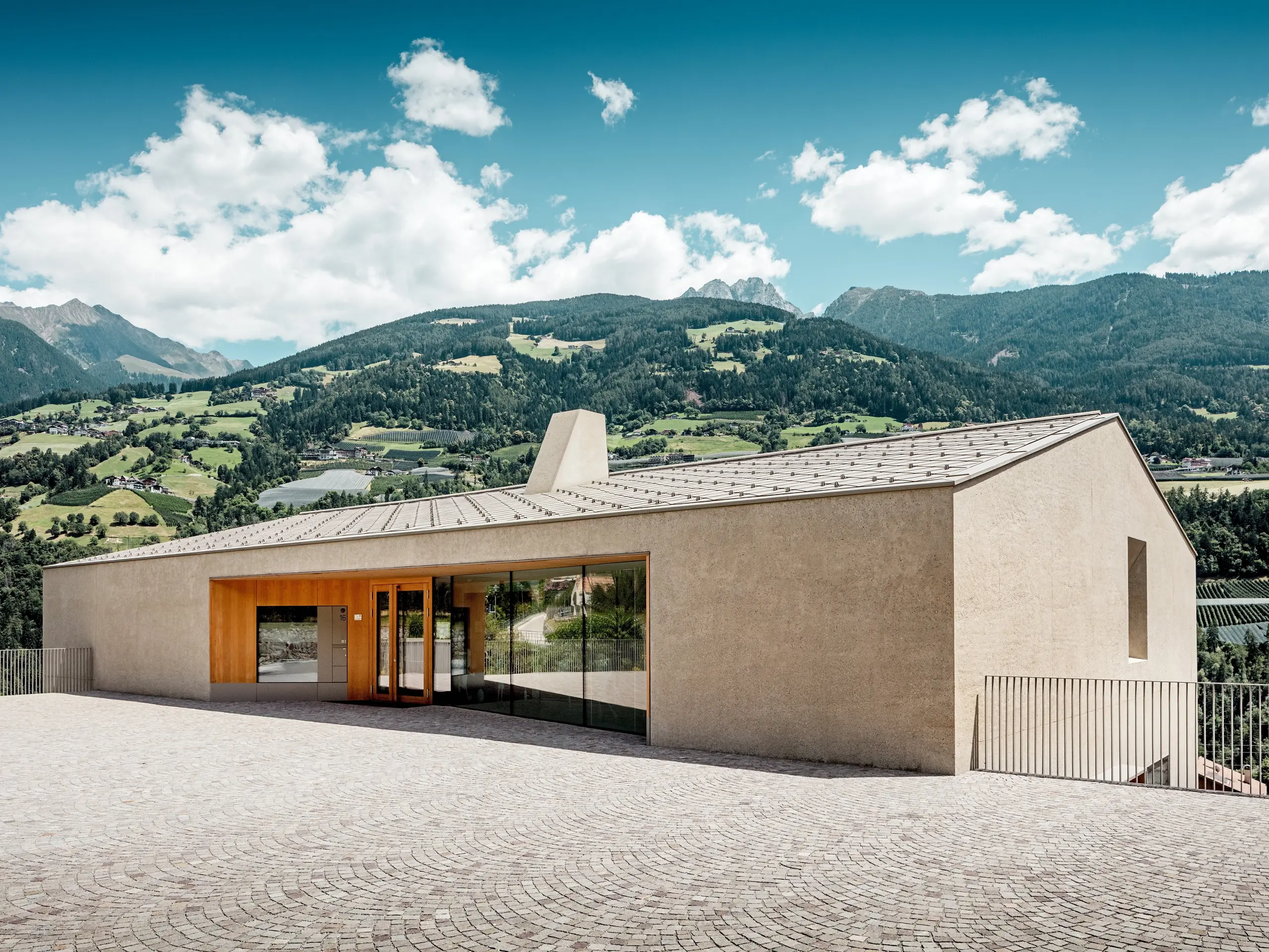 Das Bildungszentrum Riffian in Südtirol fügt sich mit seiner klaren Architektur harmonisch in die Berglandschaft ein. Das PREFA Dach mit Dachrauten 44 × 44 in P.10 Bronze überzeugt durch präzise Aluminiumverarbeitung, hohe Wetterbeständigkeit und langlebigen Schutz – ein eleganter Abschluss für Kindergarten und Volksschule.