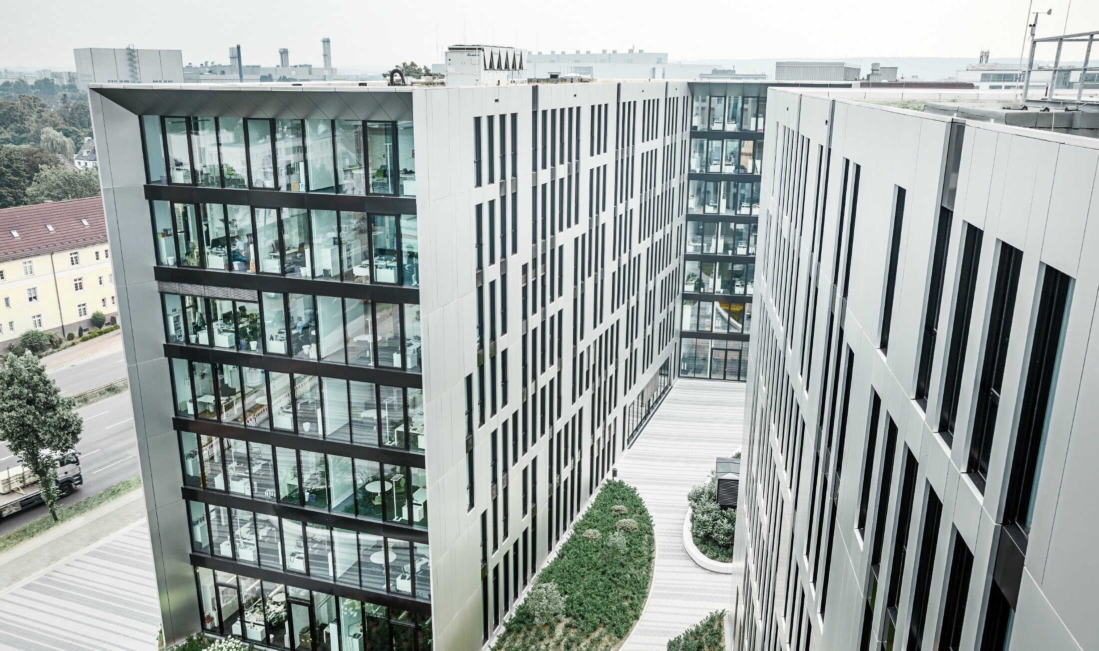 Futuristisk aluminiumfasad av samverkansplattor i borstad aluminium på byggnadskomplexet Clara & Robert i centrala Düsseldorf.