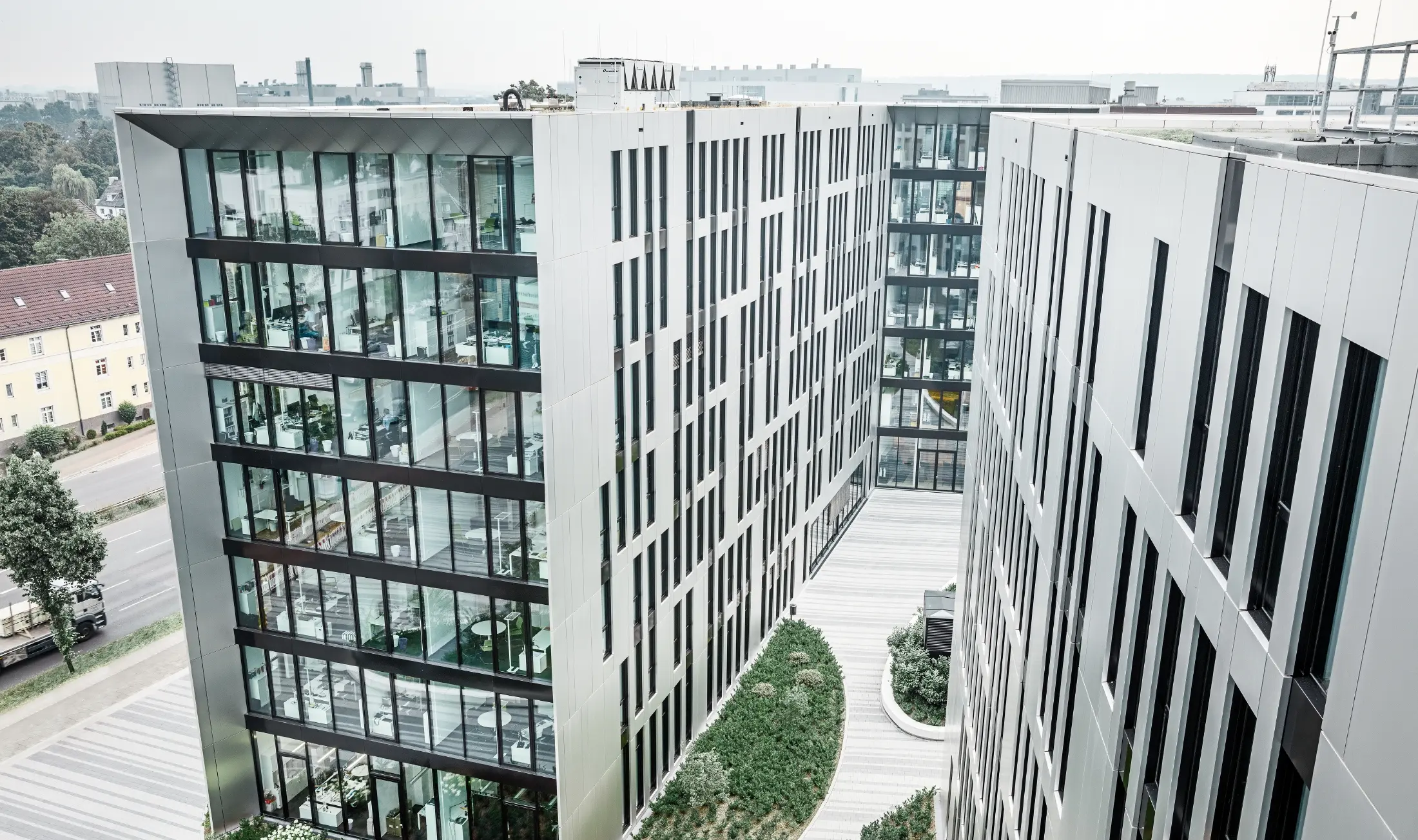 Futuristisk aluminiumfasad av samverkansplattor i borstad aluminium på byggnadskomplexet Clara & Robert i centrala Düsseldorf.