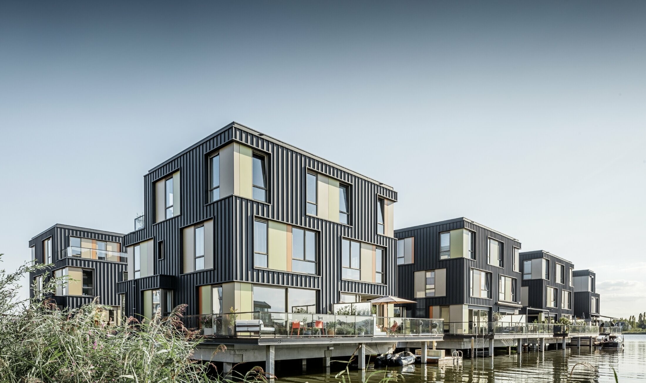 Nytt bostadsområde med tvåfamiljshus vid en sjö i Amsterdam. Husen kläddes med Prefalz från PREFA i P.10 antracit.