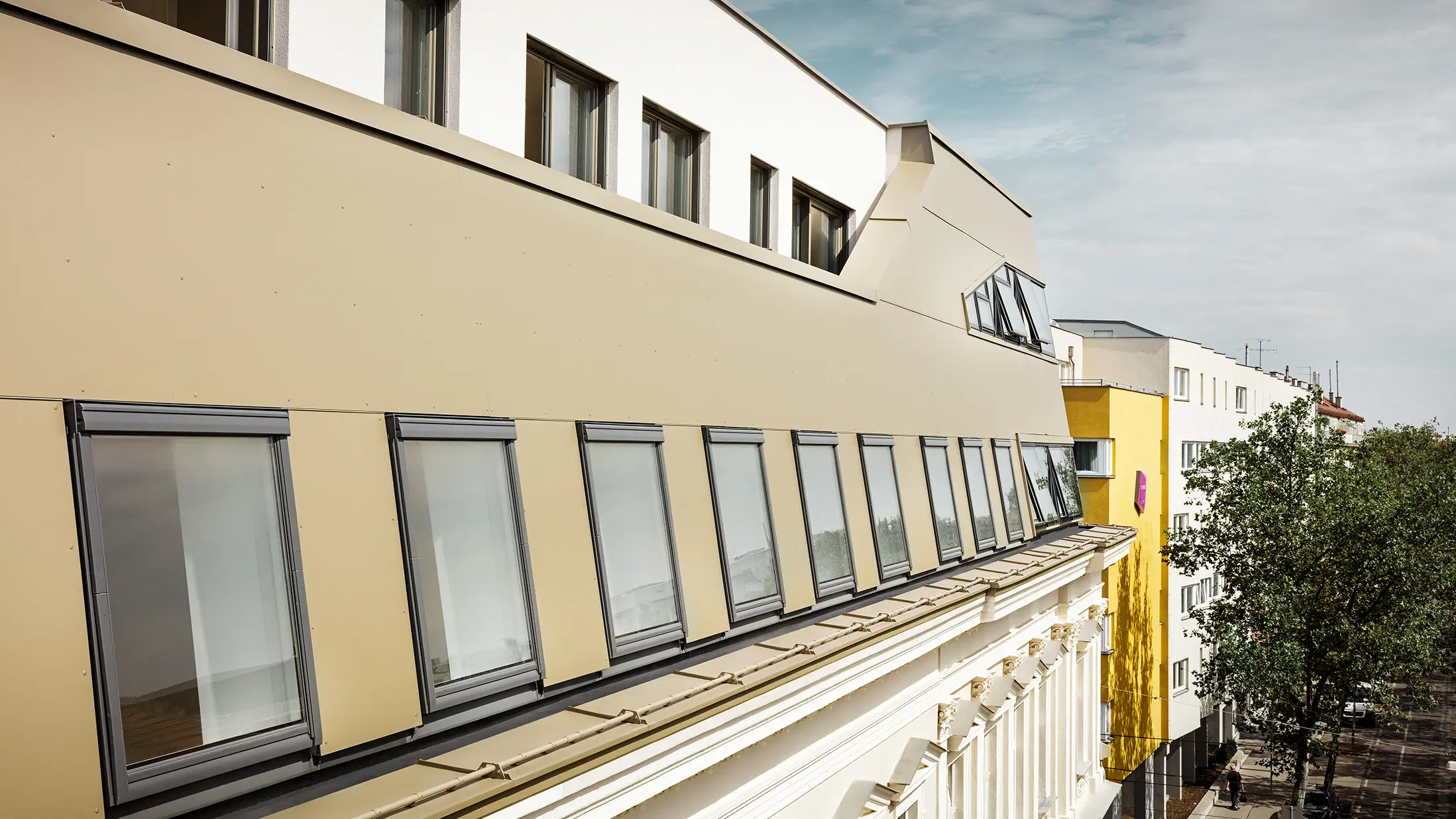 Takutbyggnad på Schloßhofer Straße i Wien med aluminiumkompositskiva i brons från PREFA