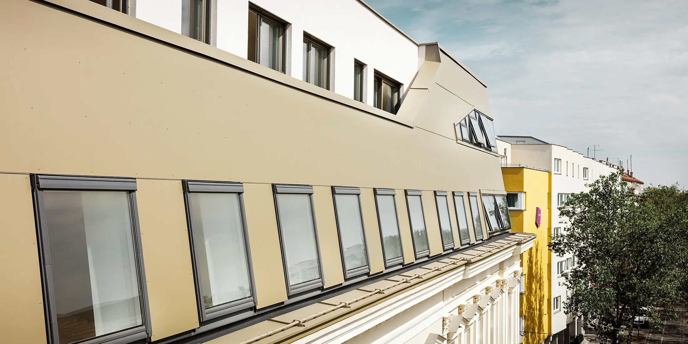Takutbyggnad på Schloßhofer Straße i Wien med aluminiumkompositskiva i brons från PREFA