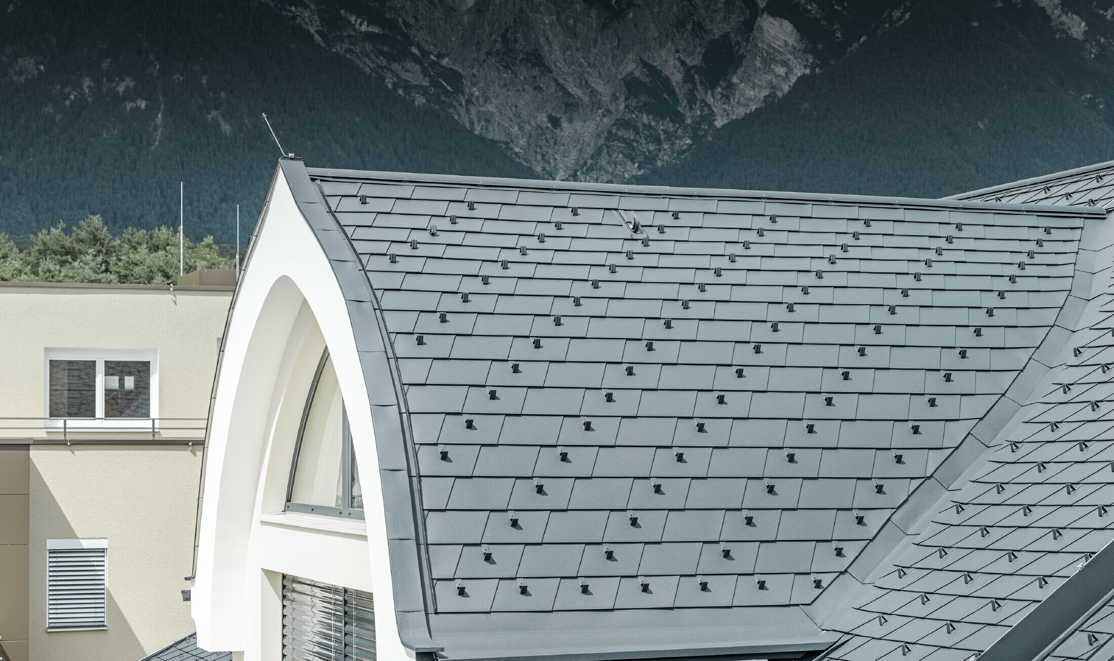 Detaljbild på takkupolen, täckt med takshingel i antracitgrått från PREFA. Takkupolen är här utformad som en solfjäder.