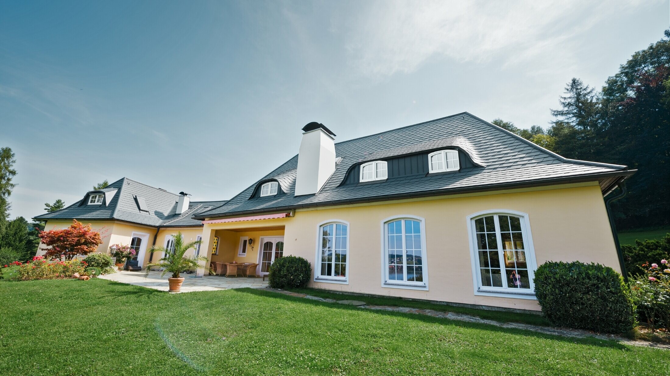 Klassiskt enfamiljshus med böjda takkupor, beklätt med stormsäkert PREFA takshingel, med 40 års materialgaranti.