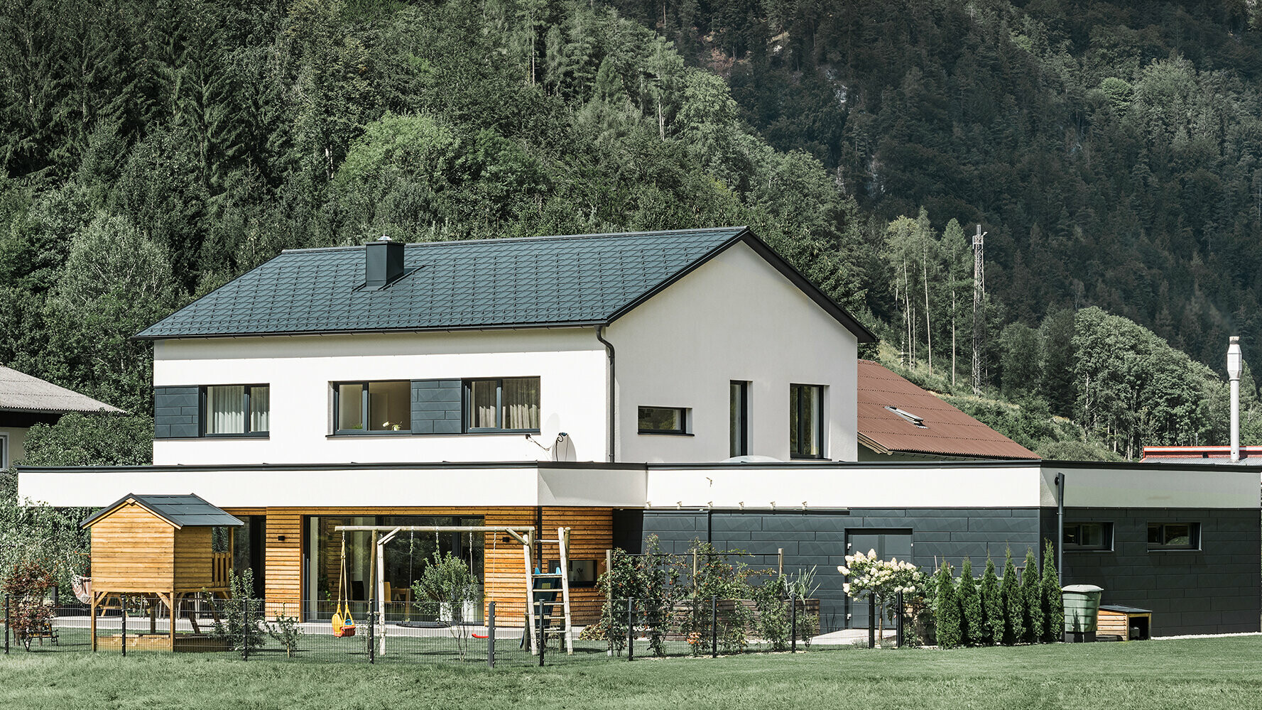 Nybyggt enfamiljshus med fasad i lärkträ kombinerat med PREFA Siding.X i antracit.