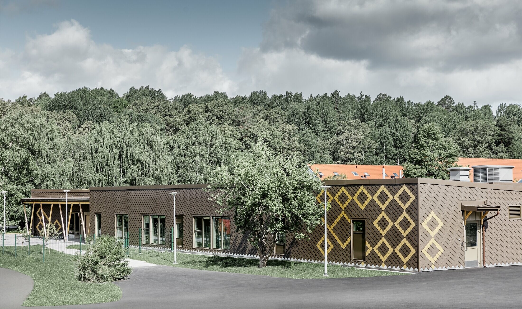 Fasadbeklädnaden på förskolan i Stockholm utfördes med PREFA väggromb 20 i färgerna brun och mayagold.