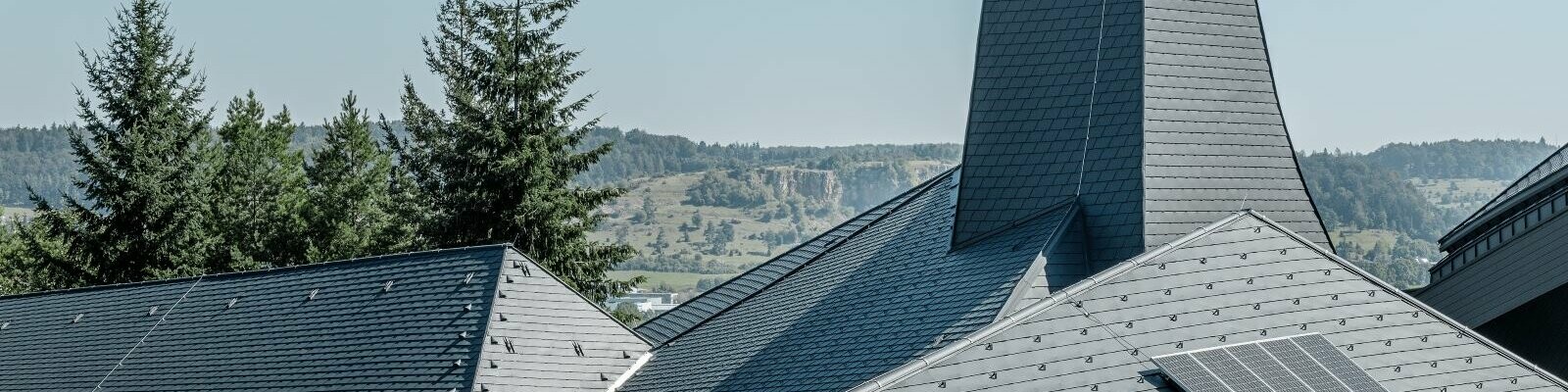 Das verwinkelte Dach der Waldorfschule Heidenheim konnte mit den flexiblen Dachschindeln von PREFA optimal eingedeckt werden