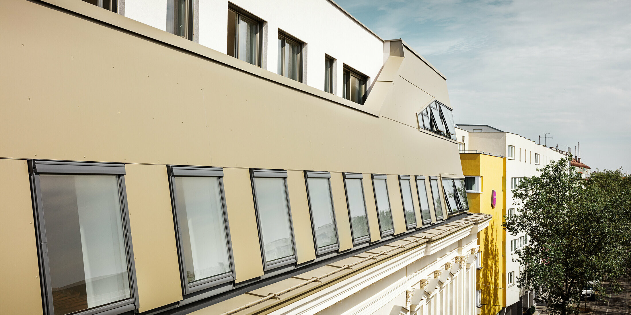 Takutbyggnad på Schloßhofer Straße i Wien med aluminiumkompositskiva i brons från PREFA