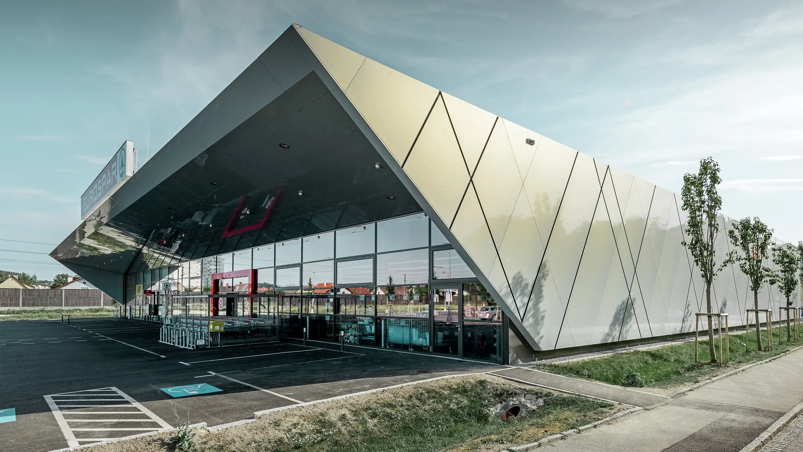 Ingången till den nya Eurospar filialen i Wels med den moderna fasadpanelen från PREFA i silverguld. Fasaden av aluminiumkomposit skimrar i solen i varierande färger beroende på betraktningsvinkeln.