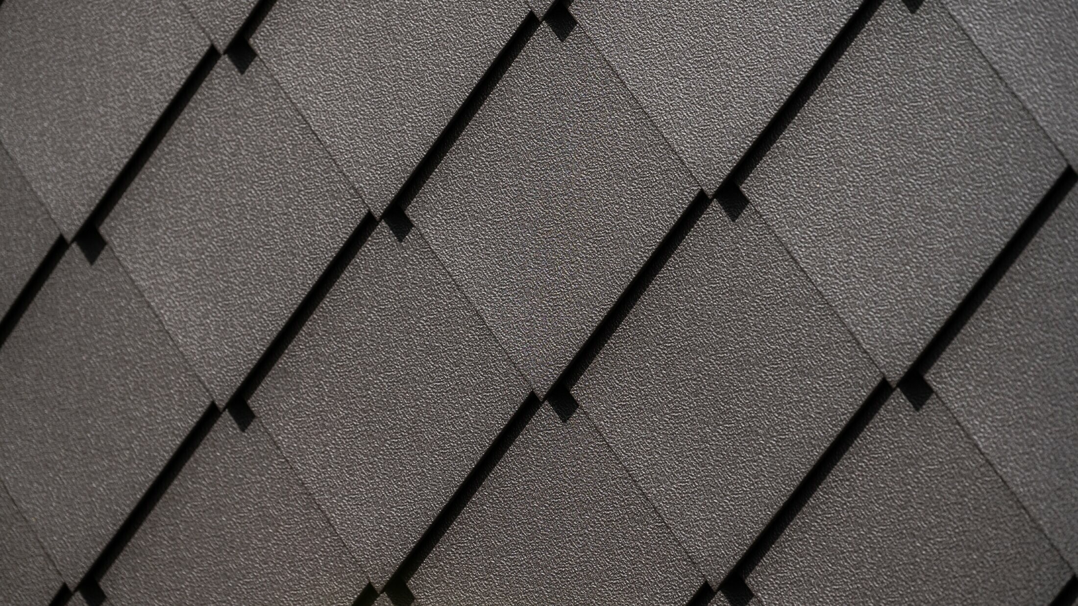 PREFA väggromb 29 × 29 i nötbrun, närbild på stucco-yta