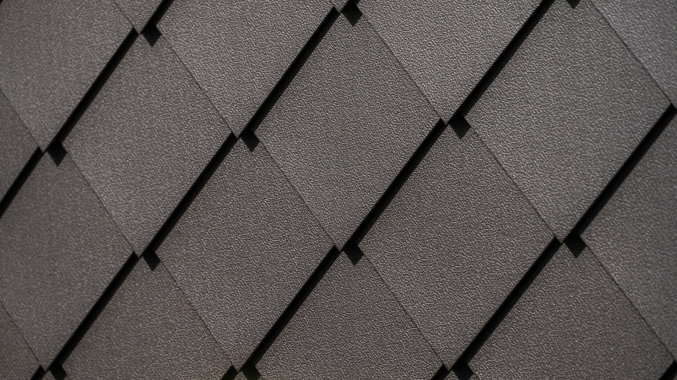 PREFA väggromb 29 × 29 i nötbrun, närbild på stucco-yta