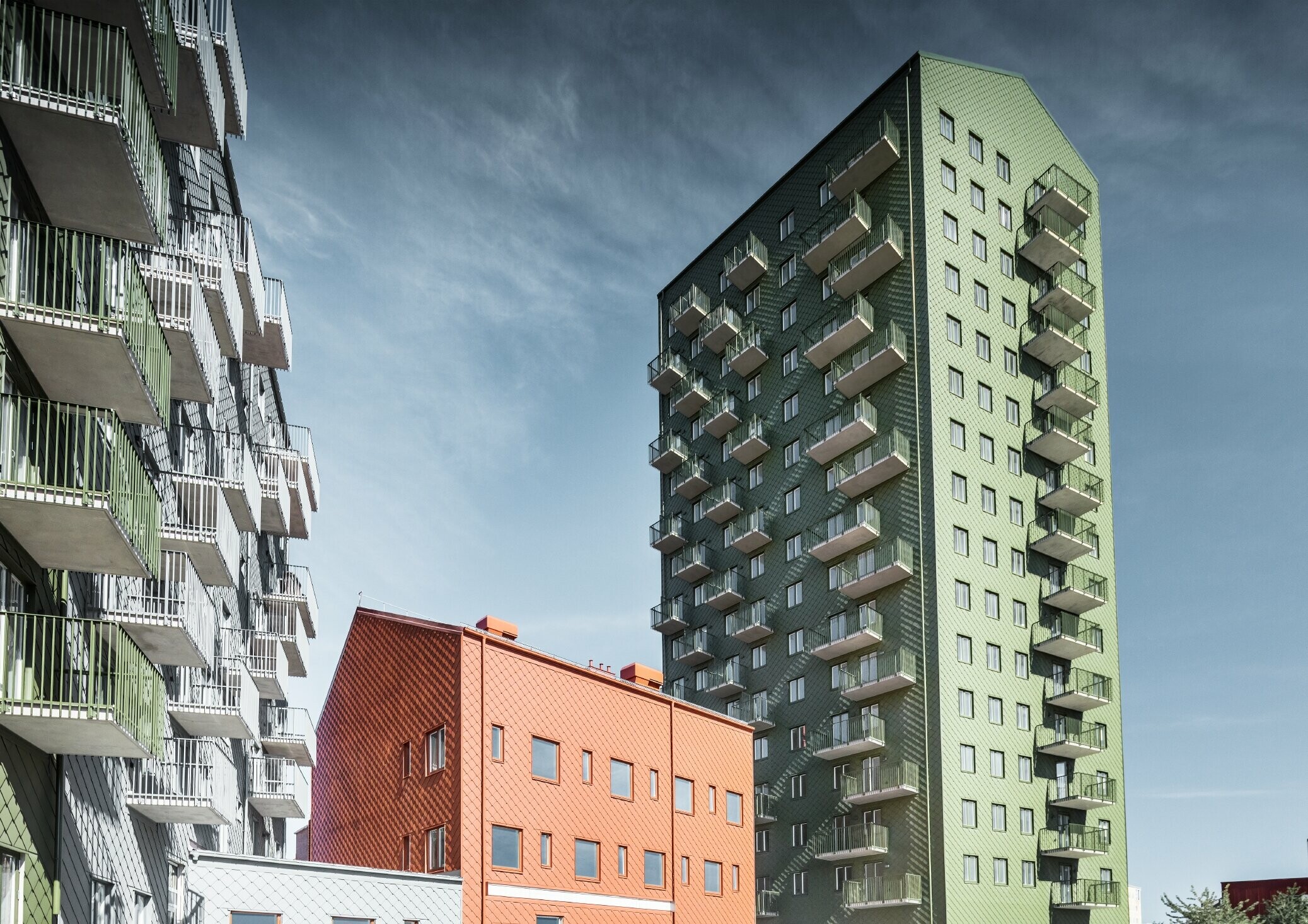 Flera bostadshus klädda med PREFA väggromber 29 × 29 i färgerna olivgrönt, tegelrött och ljusgrått i Göteborg, Sverige.