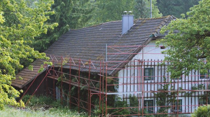 Stugans gamla tak före takrenoveringen (med byggställning) med PREFA-takshingel.