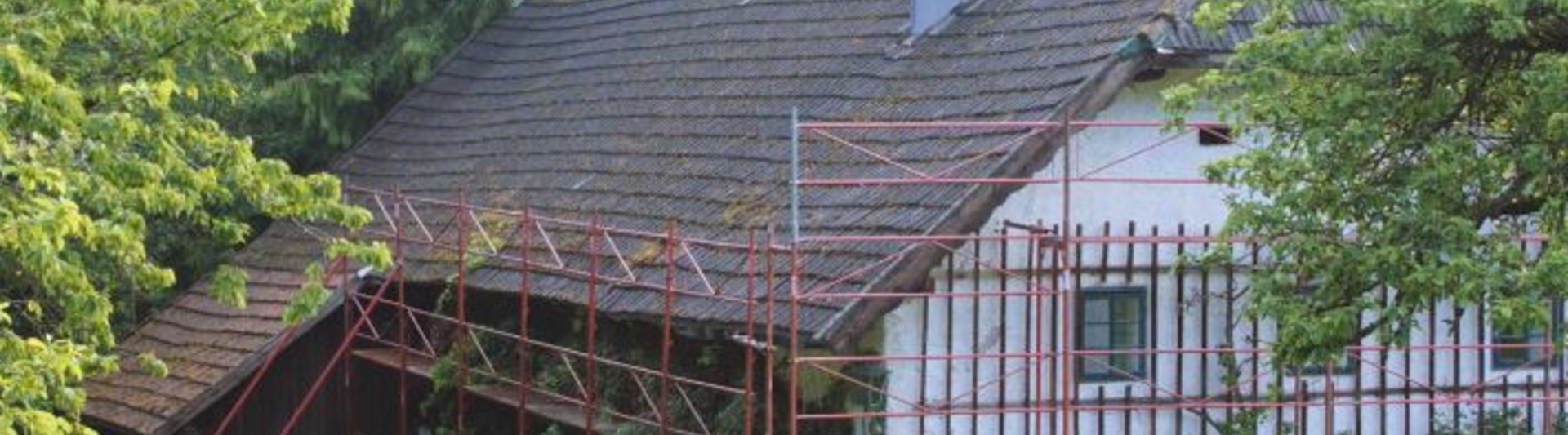 Stugans gamla tak före takrenoveringen (med byggställning) med PREFA-takshingel.