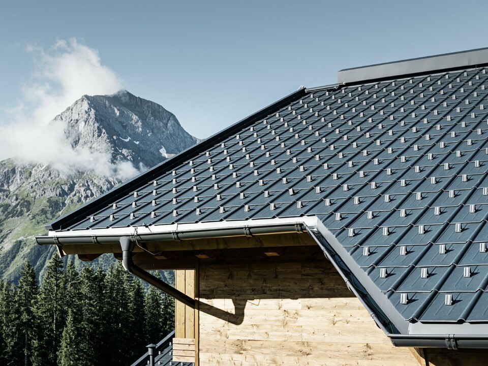 Trähus uppe i bergen: Taket är täckt med PREFA takplatta i antracit med PREFA takränna och träfasad