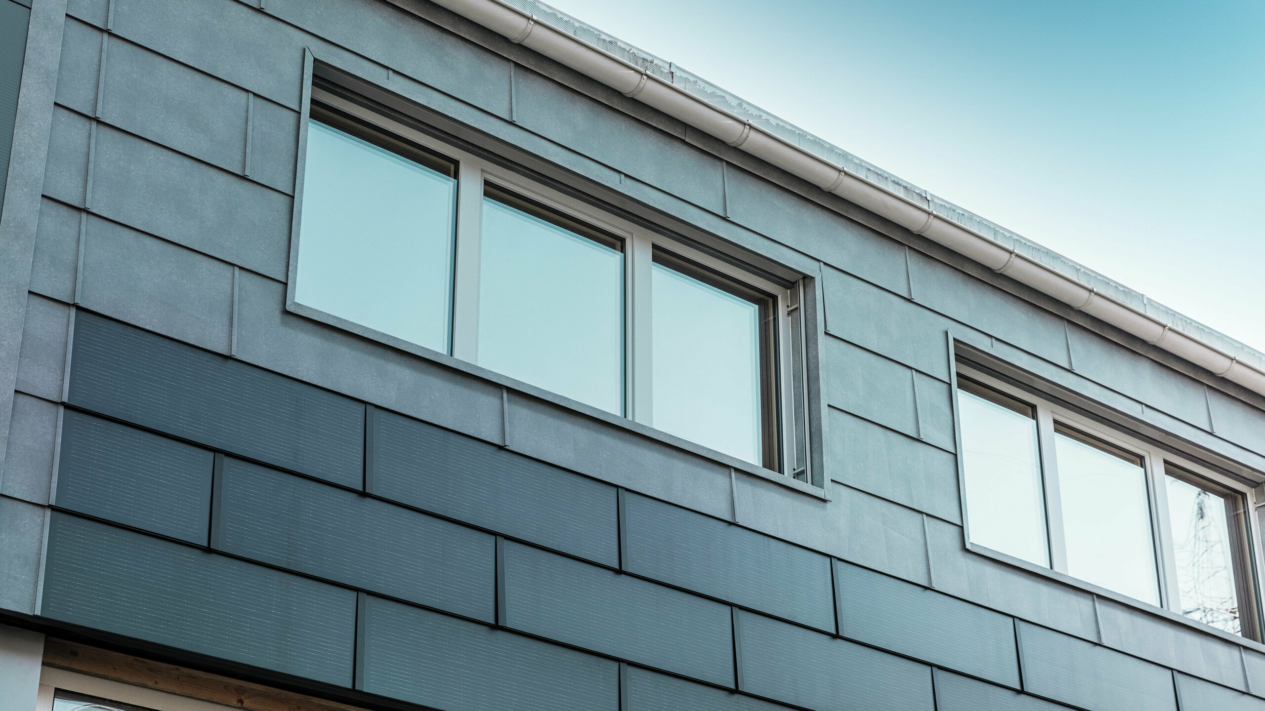 Fasadytan på företagets byggnad kläddes med innovativa solar takplattor i kombination med fasadpanelerna FX.12 från PREFA.