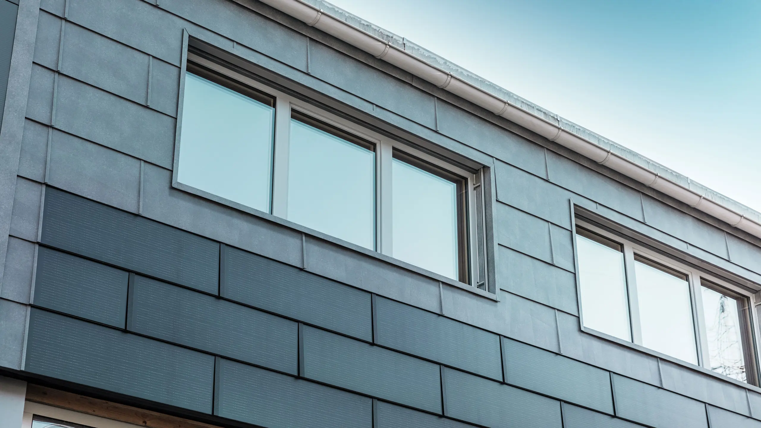 Fasadytan på företagets byggnad kläddes med innovativa solar takplattor i kombination med fasadpanelerna FX.12 från PREFA.