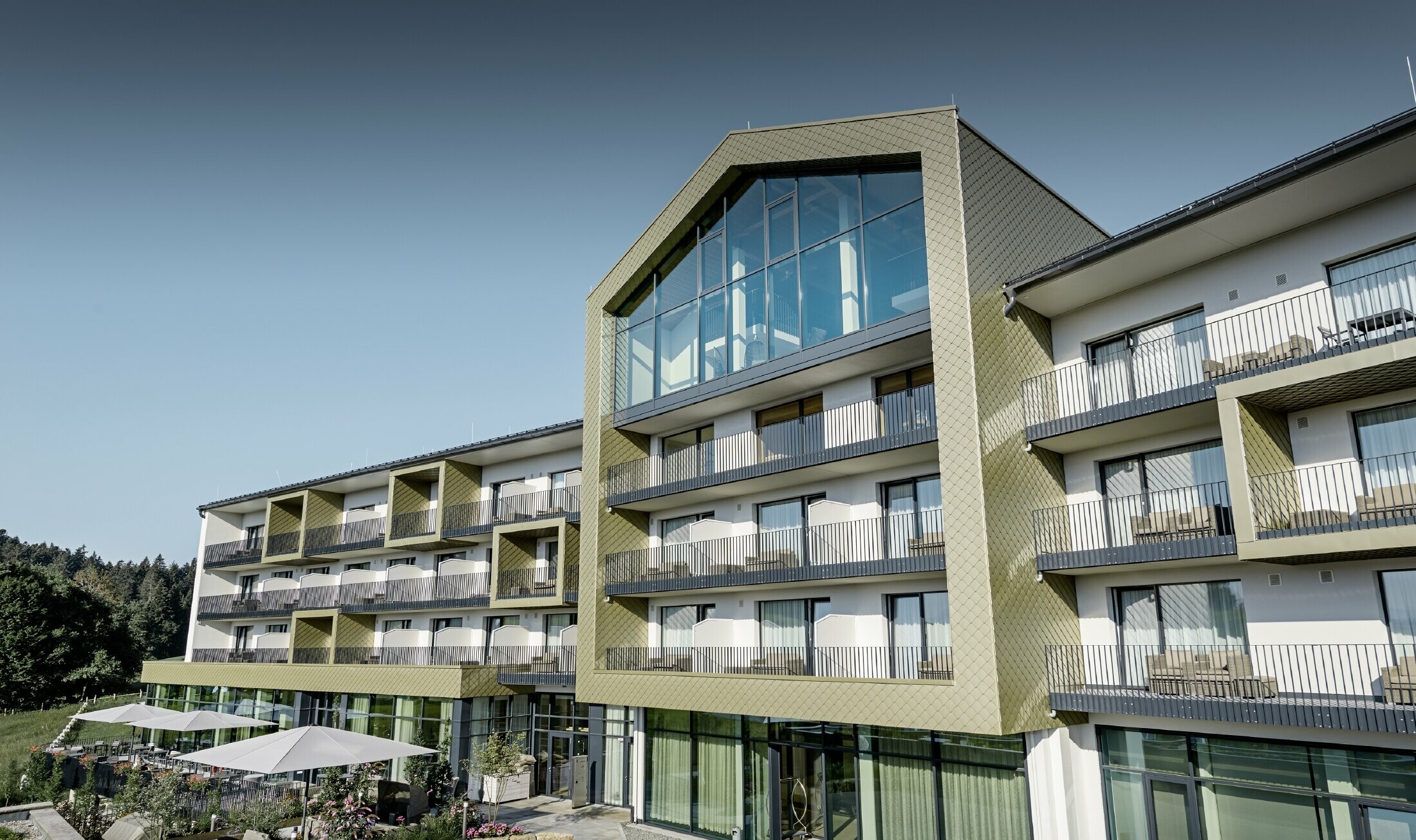 Fasaddesign av Hotel Edita i Scheidegg med aluminiumromber från PREFA i formatet 20 × 20 i specialfärgen ljus brons.