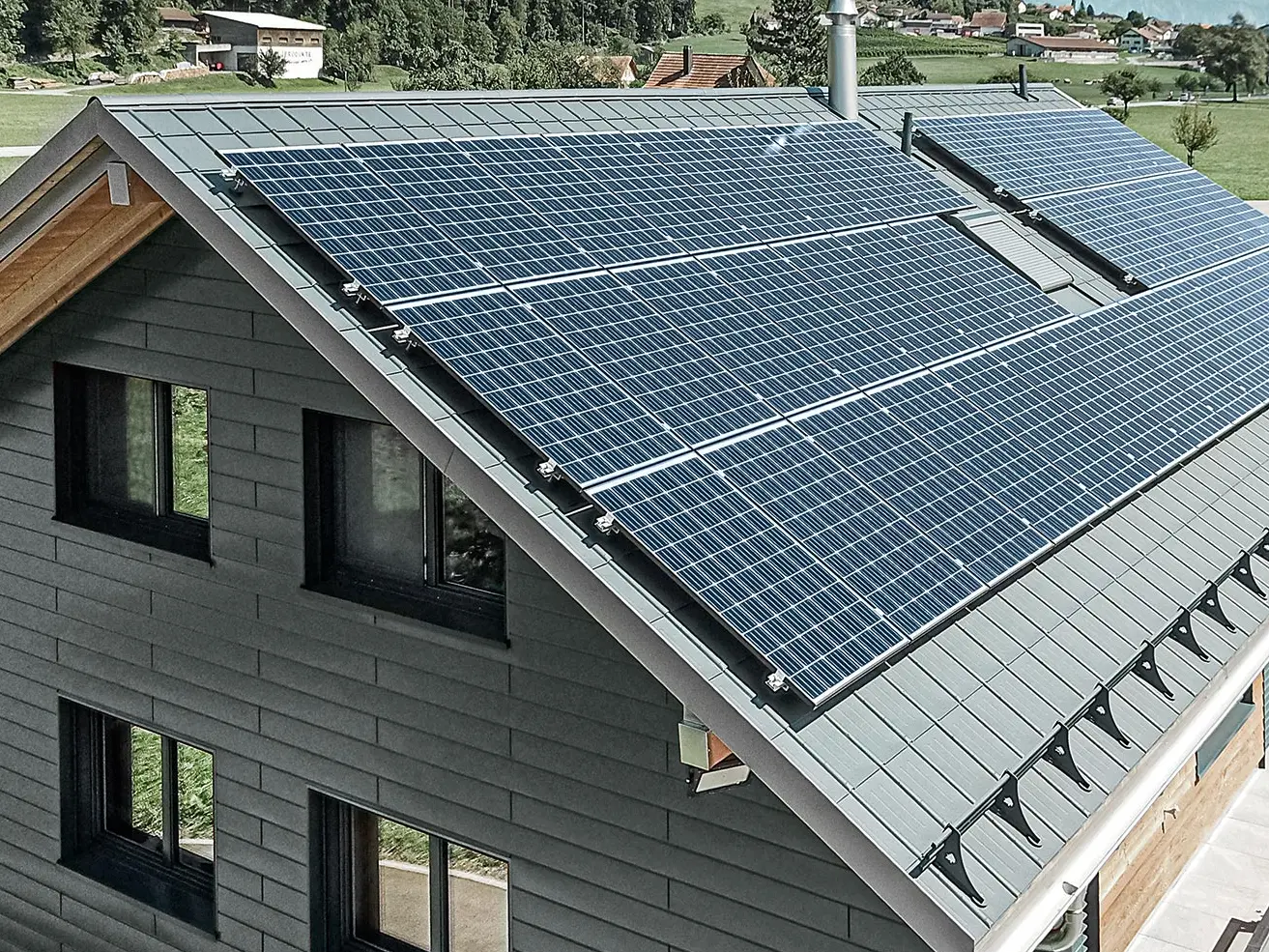 Fotovoltaikssystem monterat på PREFA-tak med solpanelhållare och profilskena för säkert fäste.